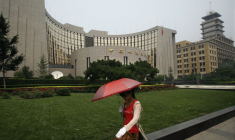 Une femme passe devant la Banque populaire de Chine, la banque centrale du pays
