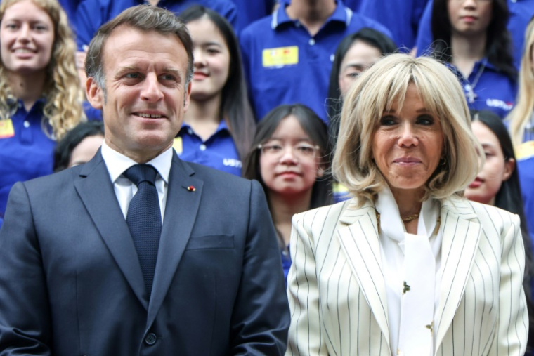 Le président français Emmanuel Macron et son épouse Brigitte Macron prennent une photo de groupe avec des étudiants vietnamiens, à l'Université des sciences et technologies d'Hanoï, le 27 mai 2025 ( AFP / Ludovic MARIN )