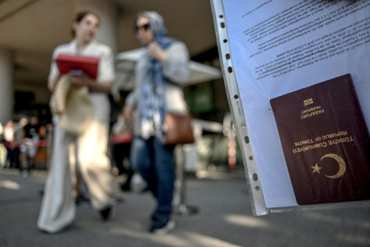 Le passeport d'un ressortissant turc dans la file d'attente devant un centre de demande de visas Schengen à Istanbul, le 30 juin 2026.   ( AFP / Ozan KOSE )