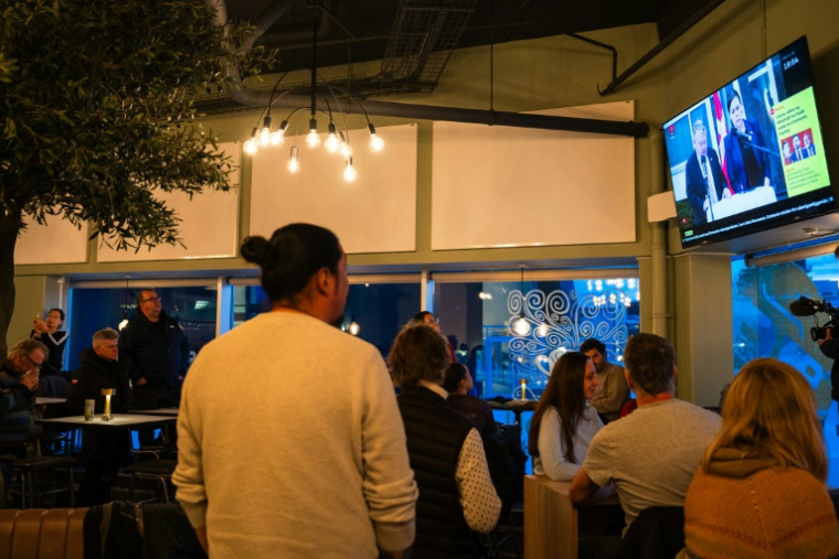 Des habitants de Nuuk regardent la conférence de presse du ministre danois des Affaires étrangères Lars Løkke Rasmussen et son homologue groenlandaise Vivian Motzfeldt, le 14 janvier 2026 ( AFP / Alessandro RAMPAZZO )