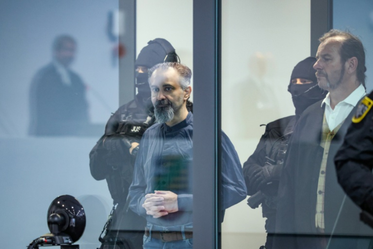 L'accusé saoudien Taleb Jawad al-Abdulmohsen (c) dans le box en verre pare-balle de la salle d'audience provisoire de Magdebourg, lors de son procès pour avoir foncé avec un SUV dans la foule d'un marché de Noël fin 2024, le 26 juin 2026 dans l'est de l'Allemagne ( AFP / Ronny HARTMANN )