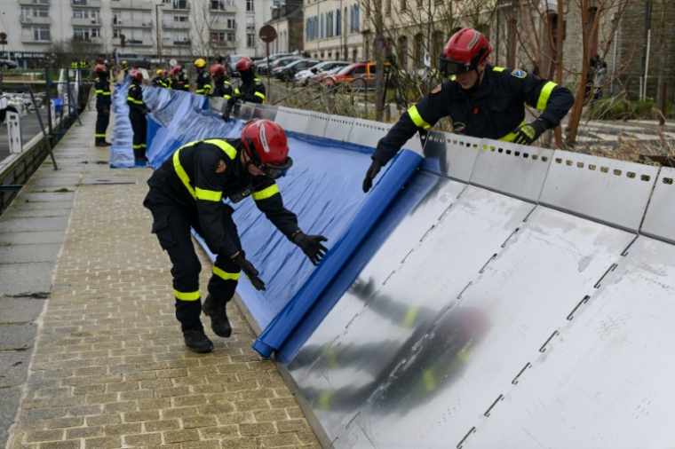 Des membres de la sécurité civile installent un barrage à Redon, en Ille-et-Vilaine, le 26 janvier 2026 ( AFP / Damien MEYER )