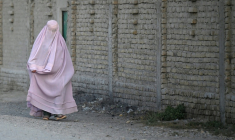 Une Afghane en burqa dans une rue du district de Dand, dans la province de Kandahar, en Afghanistan, le 11 août 2026 ( AFP / Sanaullah SEIAM )