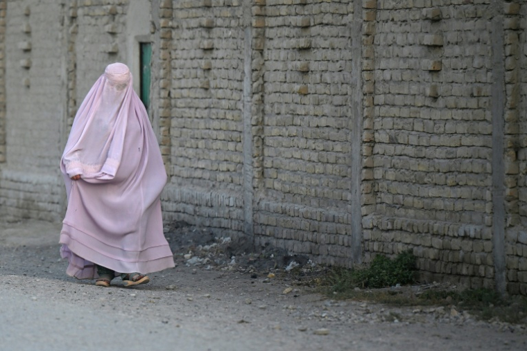 Une Afghane en burqa dans une rue du district de Dand, dans la province de Kandahar, en Afghanistan, le 11 août 2026 ( AFP / Sanaullah SEIAM )