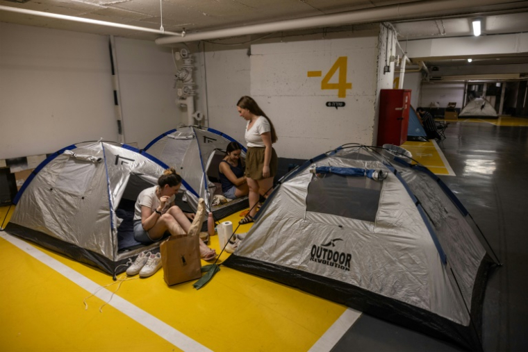Des habitants de Tel-Aviv passent la nuit dans un parking souterrain pour se mettre à l'abri des missiles iraniens, le 17 juin 2025 ( AFP / Menahem Kahana )