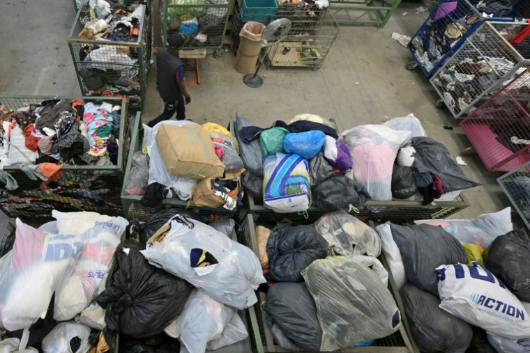 Un employé dns un centre de collecte et de tri de vêtements "Le Relais" à Acigné, près de Rennes, le 21 juillet 2025 ( AFP / Damien MEYER )