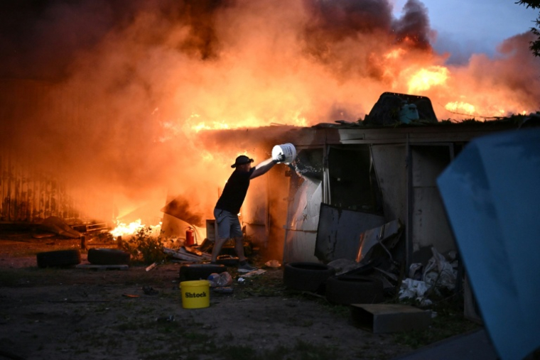Un habitant tente d'éteindre un incendie provoqué par un missile russe à Kiev, le 6 juillet 2026 ( AFP / Genya Savilov )
