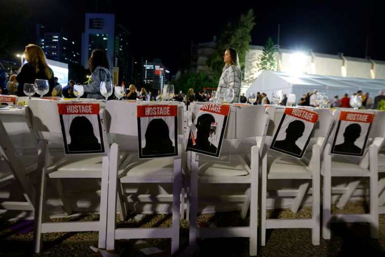 Des pancartes sont collées sur des chaises vides alors que les gens attendent des nouvelles des otages qui devraient être libérés par le Hamas