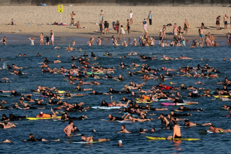 Hommage de nageurs et surfeurs aux victimes de l'attaque de Sydney à la plage de Bondi le 19 décembre 2025 ( AFP / DAVID GRAY )