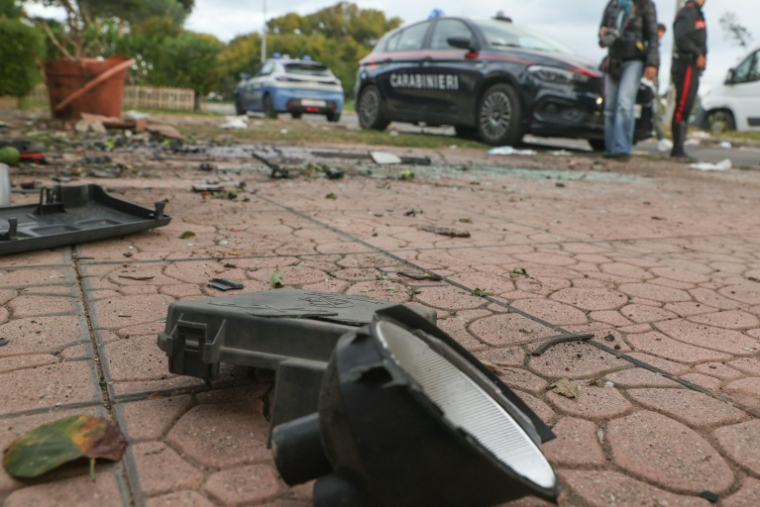 Des carabiniers italiens devant le domicile d'un journaliste d'enquête italien dont une bombe a fait exploser la voiture à Pomezia près de Rome, le 17 octobre 2025 ( ANSA / Emanuele VALERI )