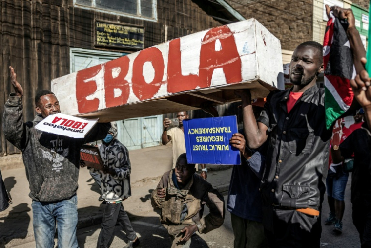 Des manifestants portent un cercueil sur lequel est écrit "Ebola" lors d'une marche contre un centre de quarantaine Ebola construit par les États-Unis sur la base aérienne de Laikipia, le 9 juin 2026 à Nanyuki, au Kenya ( AFP / Luis TATO )