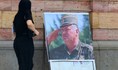 Une femme regarde un portrait de l'ancien chef militaire des Serbes de Bosnie, Ratko Mladić, devant la cathédrale orthodoxe de Banja Luka, en Bosnie, le 28 août 2026, au lendemain de sa mort à l'âge de 84 ans dans un hôpital pénitentiaire de La Haye ( AFP / STRINGER )