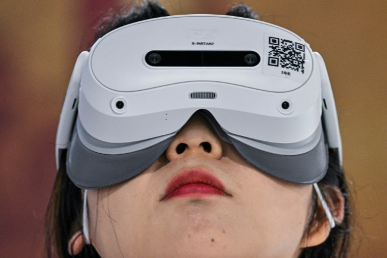Une femme utilise un casque de réalité augmentée lors de la Conférence mondiale sur l'intelligence artificielle (WAIC) au Centre mondial des expositions et des congrès de Shanghai, le 28 juillet 2025 ( AFP / Hector RETAMAL )