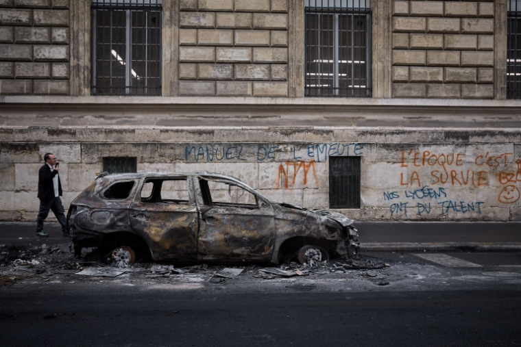 Une voiture brûlée dans le centre de Paris après un week-end de manifestations et de violences, le 19 octobre 2026 ( AFP / Kiran RIDLEY )