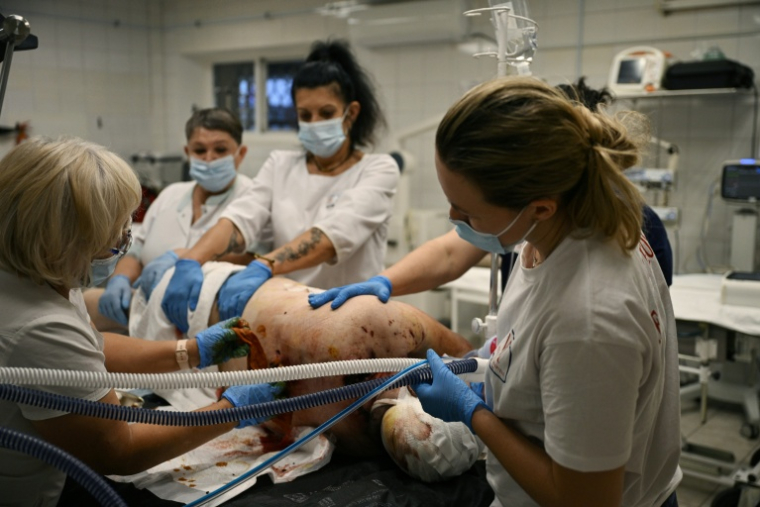 Des soignants examinent un militaire ukrainien blessé dans une salle du service de traumatologie de l'hôpital Metchnikov, à Dnipro, le 9 juin 2026, dans le cadre de l'invasion russe de l'Ukraine ( AFP / Genya SAVILOV )