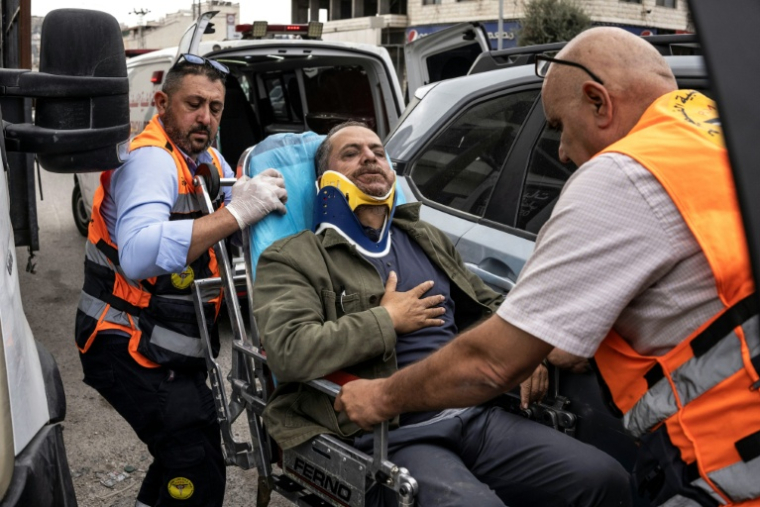 Le photographe palestinien de l'AFP Jaafar Ashtiyeh est évacué par les secours palestiniens après avoir été roué de coups par des colons israéliens à Aqraba, en Cisjordanie occupée, alors qu'il était en reportage, le 6 octobre 2026 ( AFP / JOHN WESSELS )
