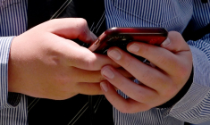Un étudiant utilise son téléphone portable à Melbourne en Australie, le 27 novembre 2024 ( AFP / William WEST )