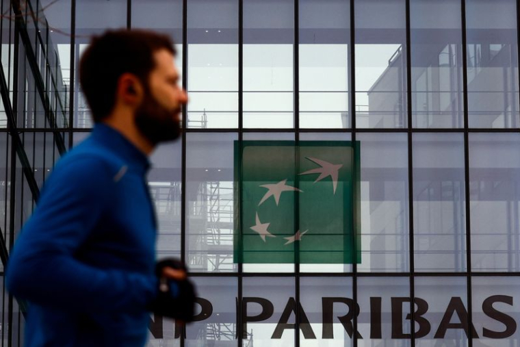 Un homme passe devant le logo de BNP Paribas dans les locaux de la banque à Issy-les-Moulineaux, près de Paris