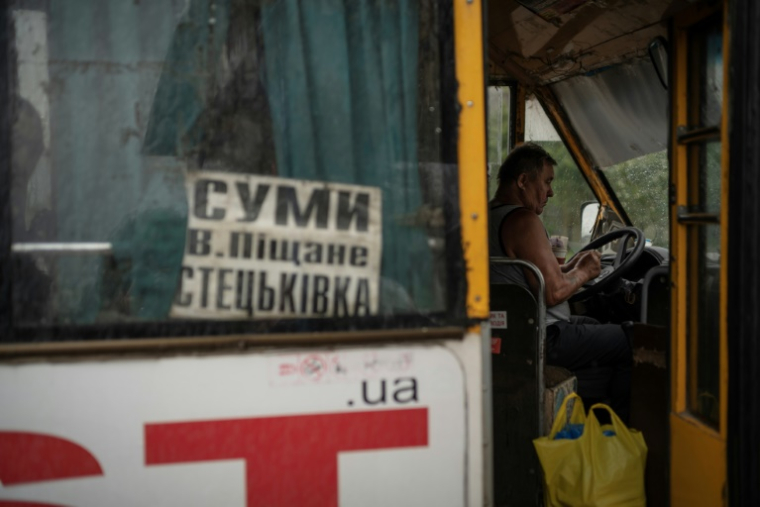 Un chauffeur de bus attend des passagers dans la localité de Stetskivka, proche de la ligne de front, dans le nord-est de l'Ukraine, le 12 juin 2025 ( AFP / Florent VERGNES )