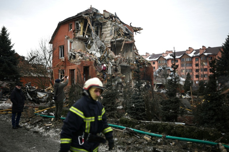 Un pompier ukrainien passe devant une maison détruite par une attaque aérienne à Sofiivska Borshchagivka, dans la région de Kiev, le 22 février 2026 ( AFP / Henry Nicholls )