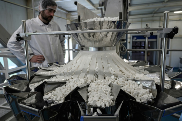 Un confiseur regarde le tri des pastilles à la menthe Vichy produites par la Maison Moinet à Hauterive, près de Vichy, le 13 mai 2025 dans l'Allier ( AFP / JEAN-PHILIPPE KSIAZEK )