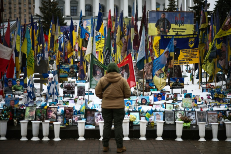 Une personne se tient devant un mémorial de fortune dédié aux soldats ukrainiens et étrangers tombés au combat, sur la place de l’Indépendance à Kiev, le 23 février 2026 ( AFP / HENRY NICHOLLS )