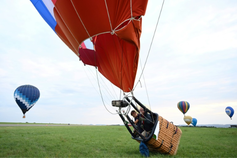 Une montgolfière atterrit près de la base de Chambley-Bussières, en Meurthe-et-Moselle, à l'occasion du festival Enenvol, le 28 juillet 2025 ( AFP / Jean-Christophe VERHAEGEN )