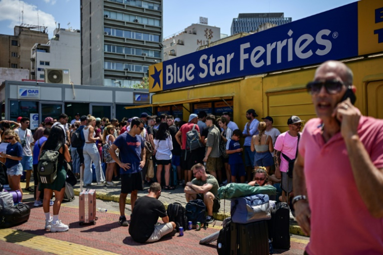 Des personnes patientent devant les guichets au port du Pirée, près d'Athènes, le 8 août 2025 ( AFP / Aris MESSINIS )