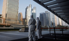 Les autorités en tenue de protection gardent l'entrée d'un immeuble de bureaux à Pékin, en Chine