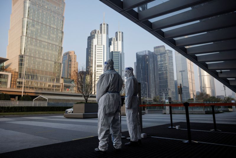 Les autorités en tenue de protection gardent l'entrée d'un immeuble de bureaux à Pékin, en Chine