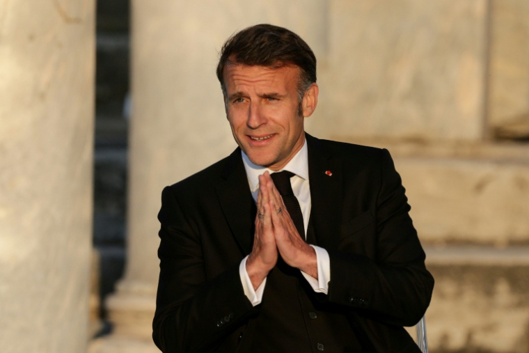 Le président français Emmanuel Macron salue le public à son arrivée sur scène lors d'un événement à l'Agora romaine d'Athènes, le 24 avril 2026 en Grèce ( AFP / Ludovic MARIN )