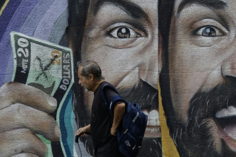Un habitant passe devant une fresque murale liée aux taux de change à Caracas, au Venezuela, le 2 juin 2025 ( AFP / Pedro MATTEY )