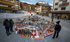 Des fleurs, des messages et des drapeaux déposés sur un mémorial improvisé le 6 janvier 2026 en hommage aux victimes de l'incendie mortel d'un bar dans la nuit du nouvel an à Crans-Montana, en Suisse ( AFP / Fabrice COFFRINI )
