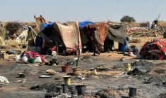 Une femme soudanaise, qui avait fui la ville d'El-Facher après sa chute, marche - le 11 février 2026 - au milieu des restes d'un incendie qui a éclaté dans le camp de Tawila ( AFP / STR )