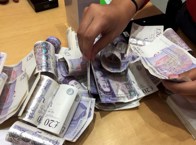 Photo de billets de livres sterling dans un magasin Apple à Londres