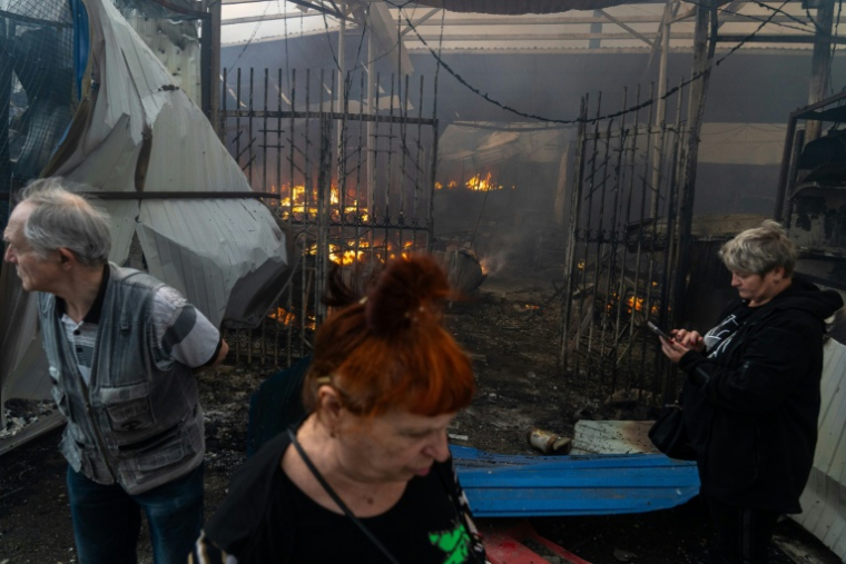 Des habitants au pied d'un immeuble visé par d'intenses bombardements russes nocturnes, le 24 mai 2026 à Kiev   ( AFP / OLEKSII FILIPPOV )