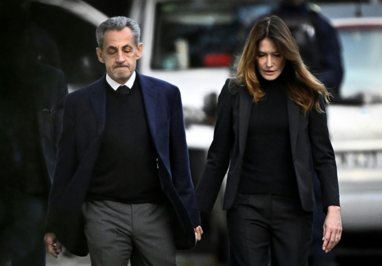 L'ex-président Nicolas Sarkozy et sa femme Carla Bruni-Sarkozy quittent leur domicile parisien le 21 octobre 2025 pour se rendre à la prison de la Santé ( AFP / JULIEN DE ROSA )