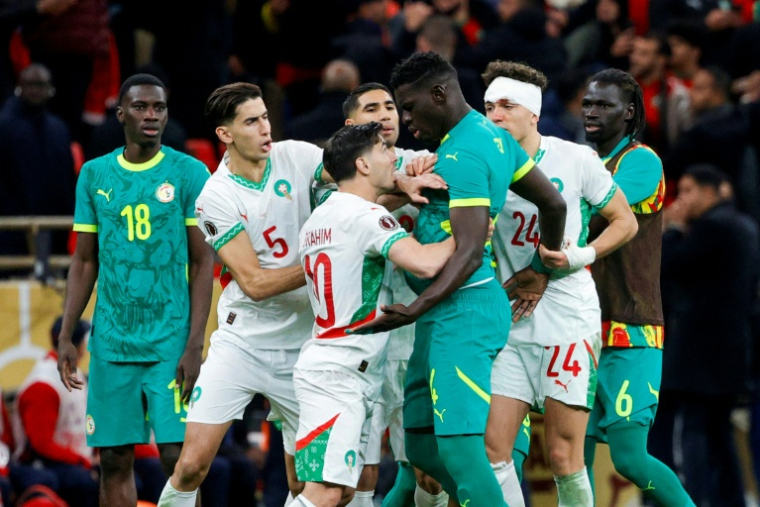 Des joueurs du Sénégal et du Maroc se prennent à partie durant une interruption de la finale de la Coupe d'Afrique des nations en raison d'un pénalty contesté, au Stade Prince Moulay Abdallah à Rabat, le 18 janvier 2026. ( AFP / Abdel Majid BZIOUAT )