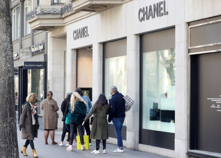Des acheteurs font la queue devant une boutique Chanel