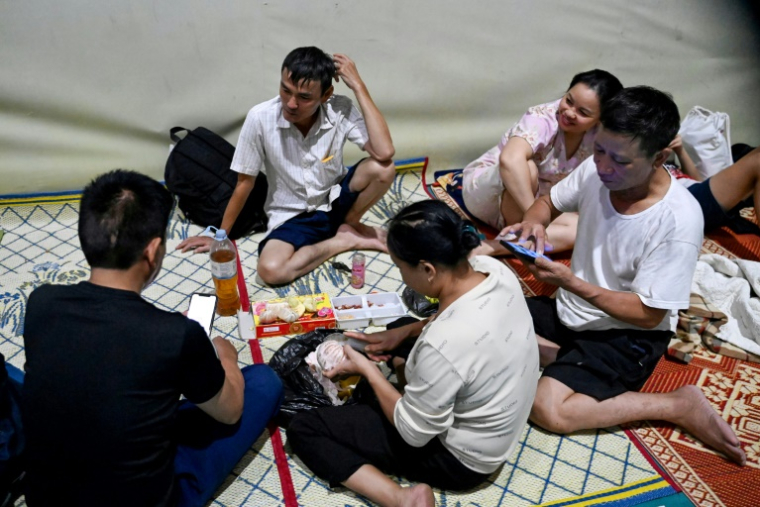 Des habitants abrités dans un gymnase à Vinh, ville côtière de la province de Nghe An, avant l'arrivée du typhon Kajiki, le 25 août 2025 au Vietnam ( AFP / Nhac NGUYEN )