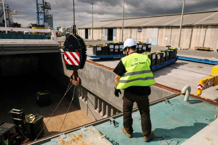 Un membre de l'équipe de World Central Kitchen travaille au chargement d'un autre bateau contenant de l'aide alimentaire à destination de Gaza