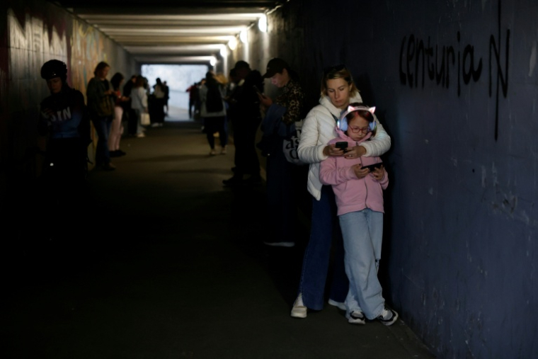 A Kiev, des passants s'abritent dans un passage souterrain pendant une alerte avertissant du danger de frappes russes, le 4 octobre 2026 ( AFP / Mykola TYMCHENKO )