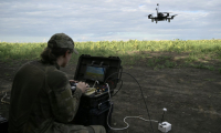 Le droniste Roubik, de la compagnie de reconnaissance du 3e corps d'armée ukrainien, contrôle un drone FPV lors d'un vol d'entraînement dans l'est de l'Ukraine, le 12 août 2025 ( AFP / Genya SAVILOV )