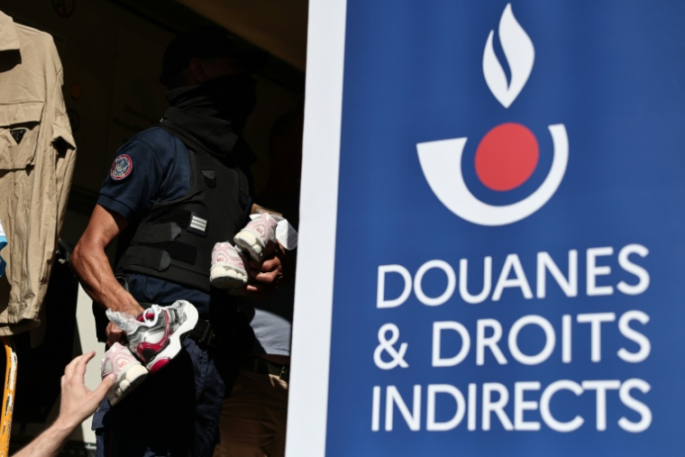 Un agent des douanes inspecte des produits contrefaits avant leur destruction à Marseille, dans le sud-est de la France, le 18 juin 2026 ( AFP / Thibaud MORITZ )