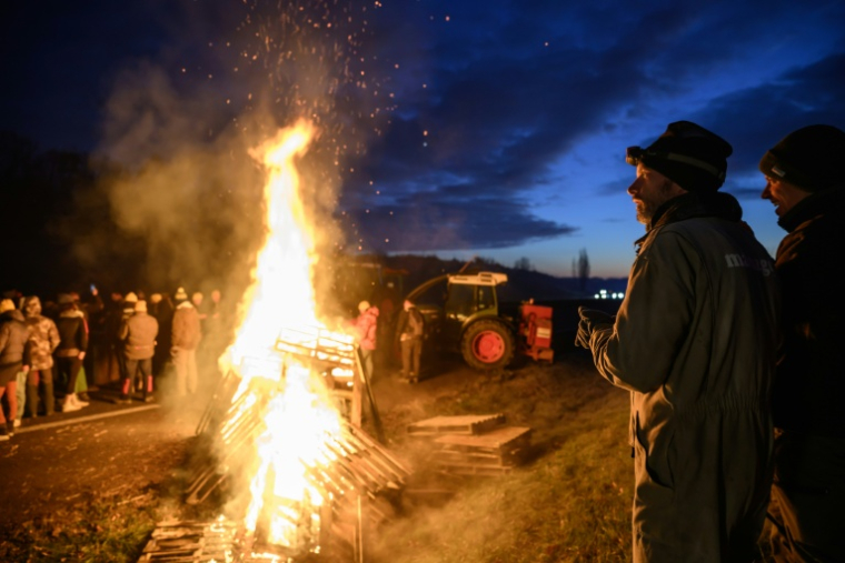 Des agriculteurs se réchauffent autour d'un feu, près de Léguevin (Haute-Garonne), le 7 janvier 2026  ( AFP / Ed JONES )