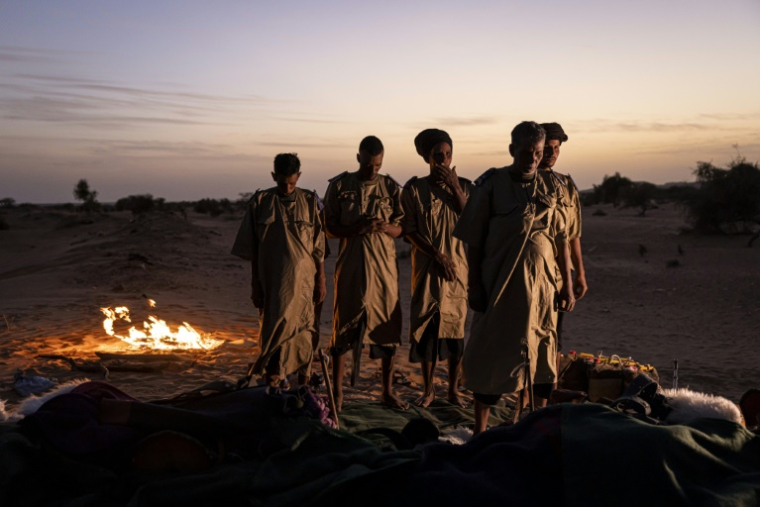 Des membres du Groupement nomade de la Garde nationale prient après avoir dressé leur campement pour la nuit à la périphérie de Oualata (Mauritanie), le 6 avril 2025 ( AFP / PATRICK MEINHARDT )