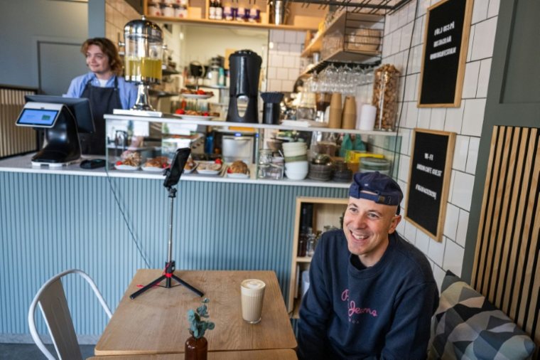 Andreu Vizquerra, un touriste espagnol, au café Andon de Stockholm, entièrement dirigé par l'IA, le 27 avril 2026 ( AFP / Jonathan NACKSTRAND )
