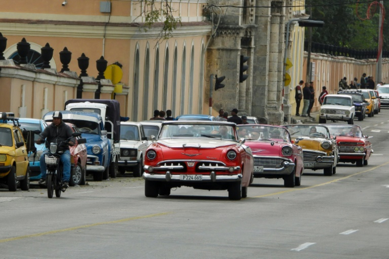 Des voitures américaines d'époque passent devant des véhicules qui font la queue pour faire le plein dans une station-service de La Havane, le 30 janvier 2026 ( AFP / ADALBERTO ROQUE )
