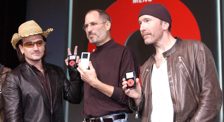 Steve Jobs (au centre) n'imaginait pas l'iPod autrement que blanc, avant d'accepter de produire une série spéciale aux couleurs de U2, en rouge et noir. (© AFP)