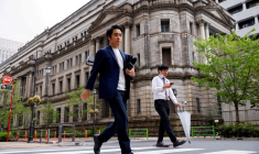 Des passants devant le bâtiment de la banque du Japon à Tokyo